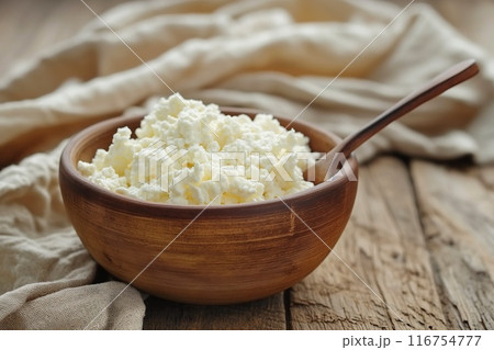 Cottage cheese in a bowl on a wooden background. Rustic style. 116754777