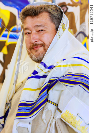 Rabbi wearing traditional Jewish clothing in synagogue during prayer 116755541