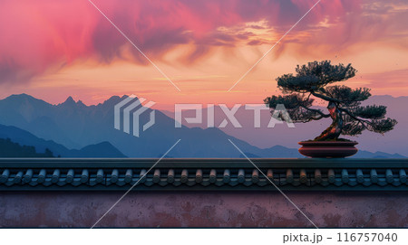 A small tree is sitting on a ledge in front of a mountain range A small tree is sitting on a ledge in front of a mountain range 116757040