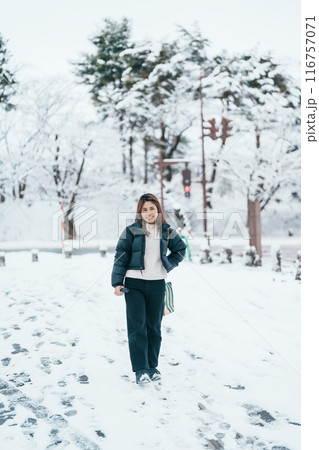 Traveler with Sweater and backpack walking on snow covered forest in frosty weather. Winter Travel, Adventure, Exploring and Vacation concept Traveler with Sweater and backpack walking on snow covered forest in frosty weather. Winter Travel, Adventure, Exploring and Vacation concept 116757071