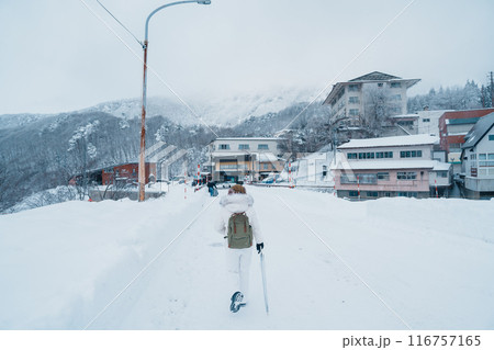 Woman tourist sightseeing Snow fall in Winter day at Zao Onsen, Yamagata prefecture, Japan. Happy Traveler walking on powder snow covered in frosty weather. Travel, Adventure and Vacation Woman tourist sightseeing Snow fall in Winter day at Zao Onsen, Yamagata prefecture, Japan. Happy Traveler walking on powder snow covered in frosty weather. Travel, Adventure and Vacation 116757165