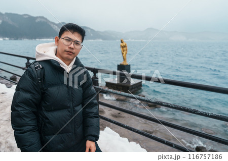 man tourist sightseeing golden Tatsuko statue and Lake Tazawa. Traveler travel in Semboku city, Akita Prefecture, Japan. Landmark for tourist attraction in Tohoku Region. Japan travel and vacation man tourist sightseeing golden Tatsuko statue and Lake Tazawa. Traveler travel in Semboku city, Akita Prefecture, Japan. Landmark for tourist attraction in Tohoku Region. Japan travel and vacation 116757186