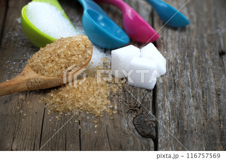 Brown cane sugar and white sugar in measuring spoons 116757569