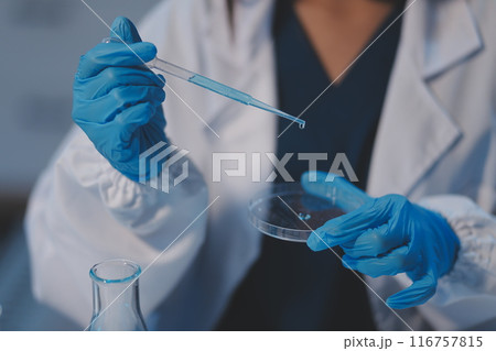 Group of dedicated scientist conduct chemical experiment in medical laboratory, carefully drop precise amount of liquid from pipette into test tube for vaccine drug or antibiotic development. Neoteric Group of dedicated scientist conduct chemical experiment in medical laboratory, carefully drop precise amount of liquid from pipette into test tube for vaccine drug or antibiotic development. Neoteric 116757815