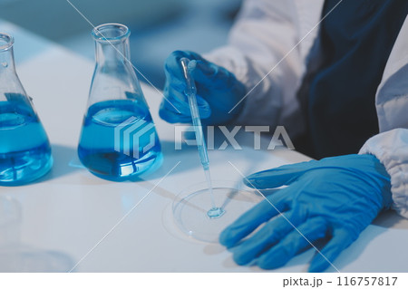 Group of dedicated scientist conduct chemical experiment in medical laboratory, carefully drop precise amount of liquid from pipette into test tube for vaccine drug or antibiotic development. Neoteric Group of dedicated scientist conduct chemical experiment in medical laboratory, carefully drop precise amount of liquid from pipette into test tube for vaccine drug or antibiotic development. Neoteric 116757817