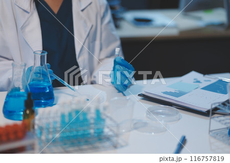 Group of dedicated scientist conduct chemical experiment in medical laboratory, carefully drop precise amount of liquid from pipette into test tube for vaccine drug or antibiotic development. Neoteric Group of dedicated scientist conduct chemical experiment in medical laboratory, carefully drop precise amount of liquid from pipette into test tube for vaccine drug or antibiotic development. Neoteric 116757819
