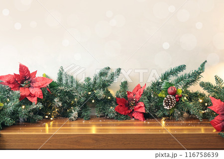 Christmas decoration on table. Background for design. Spruce branches and poinsettia flowers. Garland with lights.  116758639