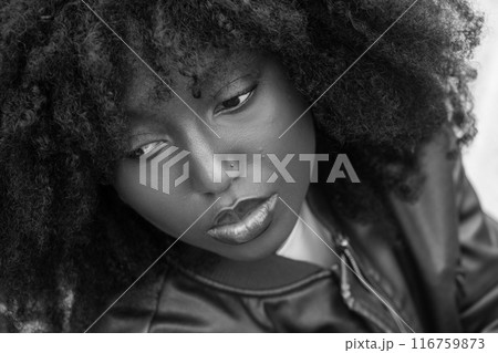 Contemplative portrait of a woman with curly hair in monochrome, highlighting artistic beauty 116759873