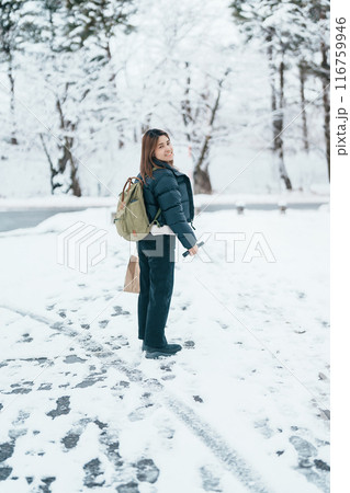 Traveler with Sweater and backpack walking on snow covered forest in frosty weather. Winter Travel, Adventure, Exploring and Vacation concept Traveler with Sweater and backpack walking on snow covered forest in frosty weather. Winter Travel, Adventure, Exploring and Vacation concept 116759946