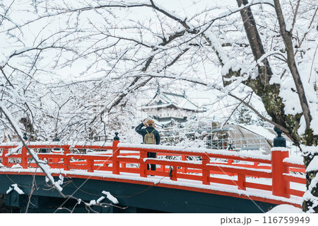 Woman tourist sightseeing Hirosaki Castle in winter, happy traveler travel Hirosaki city, Aomori Prefecture, Tohoku, Japan. Landmark and famous for tourist attraction. Japan travel and vacation Woman tourist sightseeing Hirosaki Castle in winter, happy traveler travel Hirosaki city, Aomori Prefecture, Tohoku, Japan. Landmark and famous for tourist attraction. Japan travel and vacation 116759949