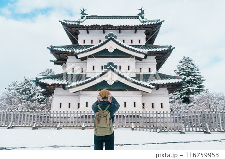 Woman tourist sightseeing Hirosaki Castle in winter, happy traveler travel Hirosaki city, Aomori Prefecture, Tohoku, Japan. Landmark and famous for tourist attraction. Japan travel and vacation 116759953