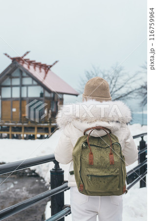 Woman tourist sightseeing Kansa Shrine and Lake Tazawa in winter. Traveler travel in Semboku city, Akita Prefecture, Japan. Landmark for tourist attraction in Tohoku region. Japan travel and vacation 116759964