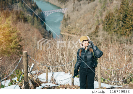 Woman tourist sightseeing View of Japan local train with Tadami river and bridge. Traveler travel at Tadami Railway Line in Mishima Machi, Aizu, Fukushima Prefecture, Japan. Landmark and iconic spot 116759988