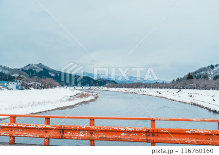 Hinokinai River riverbank with Yokomachi Bridge in winter season. Beautiful sakura trees flowers with snow and mountains locate in Kakunodate town, Semboku District, Akita Prefecture, Japan 116760160