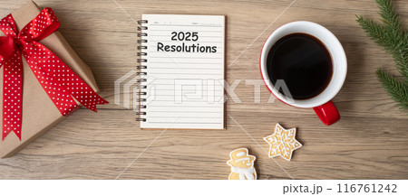 2025 Resolutions with notebook, black coffee cup, Christmas cookies and pen on wood table, Top view and copy space. Xmas, Happy New Year, Goals, To do list, Strategy and Plan concept 116761242