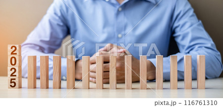 Businessman with 2025 wooden Blocks. Business, Risk Management, Insurance, Resolution, strategy, solution, goal, New Year New You and happy holiday concepts Businessman with 2025 wooden Blocks. Business, Risk Management, Insurance, Resolution, strategy, solution, goal, New Year New You and happy holiday concepts 116761310