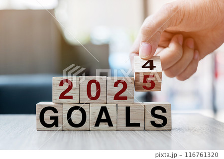 Businessman hand holding wooden cube with flip over block 2024 to 2025 Plans word on table background. Resolution, strategy, solution, goal, business and New Year holiday concepts 116761320
