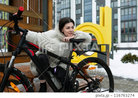 Woman Sitting on Bench Next to Bike 116763274