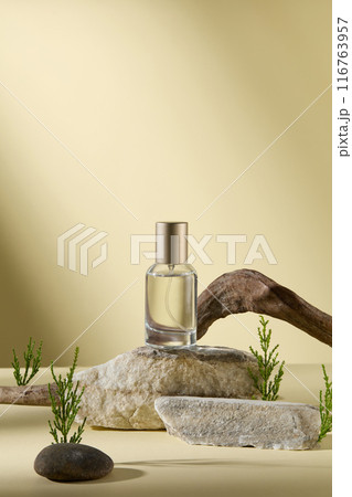 Cosmetic advertising mock up with an unbranded serum bottle contains transparent liquid placed on a stone in center, over yellow background. Front view, copy space for adding text Cosmetic advertising mock up with an unbranded serum bottle contains transparent liquid placed on a stone in center, over yellow background. Front view, copy space for adding text 116763957