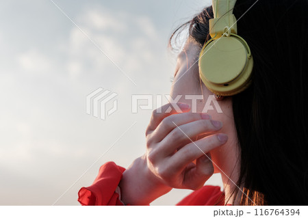 博多駅の屋上で音楽を聴きながら外を眺める女性 116764394