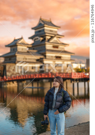 Woman tourist Visiting in Matsumoto, happy Traveler sightseeing Matsumoto Castle or Crow castle. Landmark and popular for tourists attraction in Matsumoto, Nagano, Japan. Travel and Vacation concept 116764946