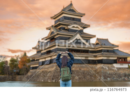 Woman tourist Visiting in Matsumoto, happy Traveler sightseeing Matsumoto Castle or Crow castle. Landmark and popular for tourists attraction in Matsumoto, Nagano, Japan. Travel and Vacation concept 116764973