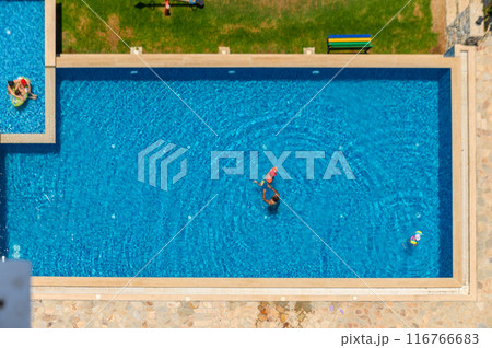 A top down shot directly above an empty pool, surrounded by green grass and trees A top down shot directly above an empty pool, surrounded by green grass and trees 116766683