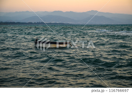 Silhouette of fishing boat on sea beach with sunset background. Silhouette of fishing boat on sea beach with sunset background. 116766697