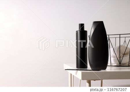 Bottle with men's cosmetics and basket with towels on table on white background, space for text Bottle with men's cosmetics and basket with towels on table on white background, space for text 116767207