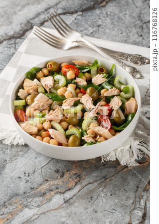 Tuna chickpea salad with tomatoes, spinach, celery dressed with olive oil close-up in a bowl. Vertical Tuna chickpea salad with tomatoes, spinach, celery dressed with olive oil close-up in a bowl. Vertical 116768126