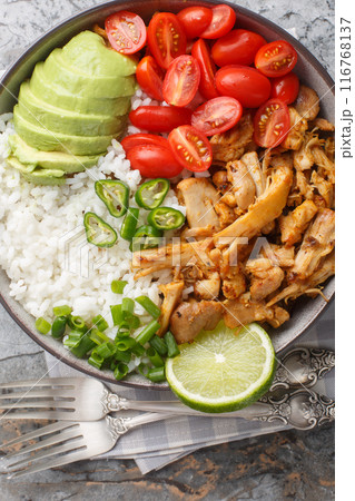 Chicken Carnitas bowl or burrito bowl with rice, tomatoes, jalapeno pepper and avocado close-up. Vertical top view 116768137