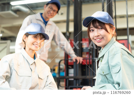 フォークリフトの前に集まる男女3人の作業着姿の作業員 116769260