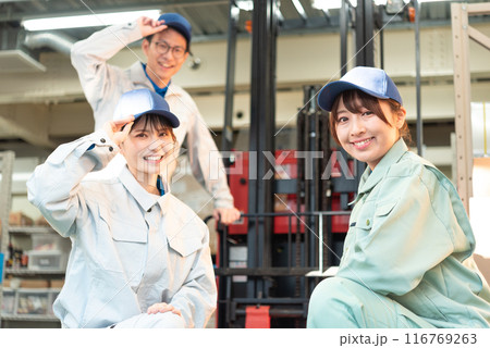 フォークリフトの前に集まる男女3人の作業着姿の作業員 フォークリフトの前に集まる男女3人の作業着姿の作業員 116769263