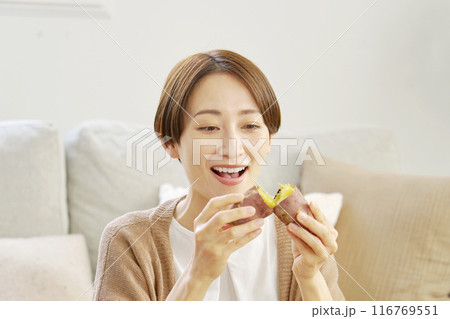 自宅で焼き芋を食べる女性 116769551