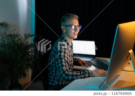 Focused Man Working on Computer Late at Night in Office Focused Man Working on Computer Late at Night in Office 116769860