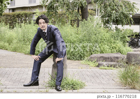 屋外で座っている男性 116770218
