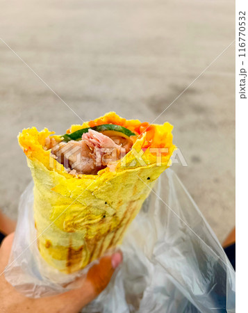 Shawarma in cheese lavash in a man's hand. fast food 116770532