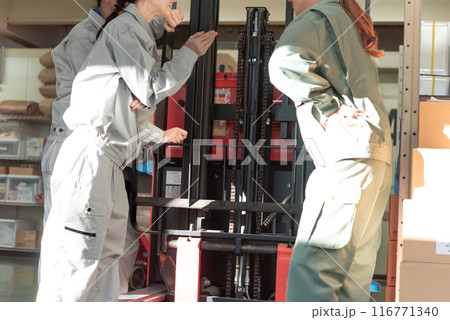 フォークリフトの点検をする男女3人の作業員 116771340