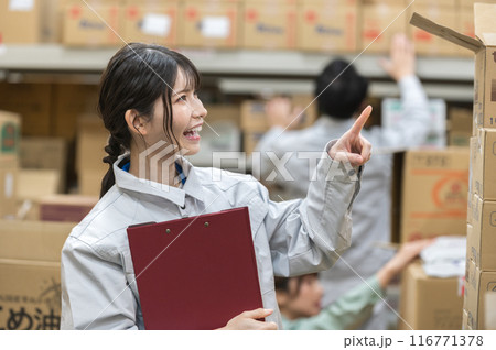 倉庫で検品作業する作業着姿の若い女性 116771378