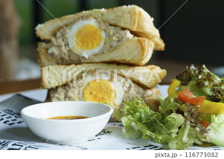 Crispy toasted bread filled with tuna salad and a halved hard boiled egg. Crispy toasted bread filled with tuna salad and a halved hard boiled egg. 116773082