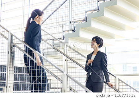 オフィスで会話する女性ビジネスパーソン 116773515