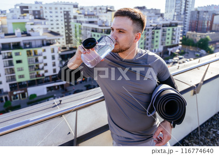happy bearded sporty handsome man going to workout Gym or yoga practice on the city street with a mat and a bottle of water in his hands. walk outdoors outside on park alley Fitness male enjoy goal happy bearded sporty handsome man going to workout Gym or yoga practice on the city street with a mat and a bottle of water in his hands. walk outdoors outside on park alley Fitness male enjoy goal 116774640