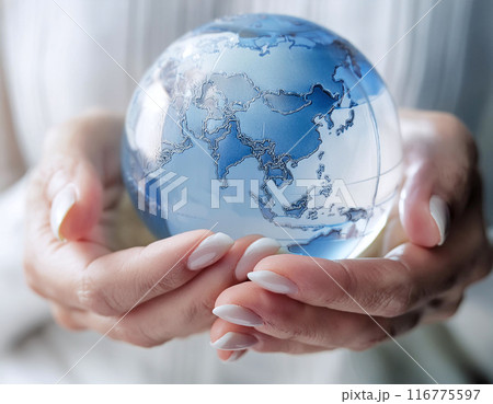 小さな透明のガラスの地球儀を持つ女性の手のひらの画像 116775597