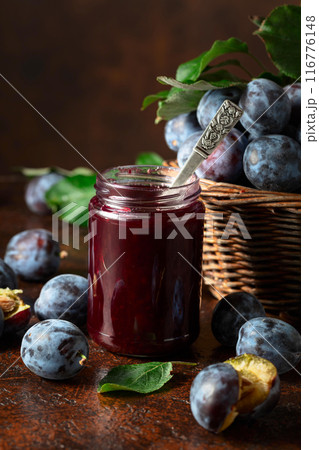 Plum jam and fresh berries on a brown vintage table. 116776148