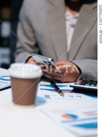 Business woman using calculator and writing make note with calculate. Woman working at office with laptop and documents on his desk Business woman using calculator and writing make note with calculate. Woman working at office with laptop and documents on his desk 116776805