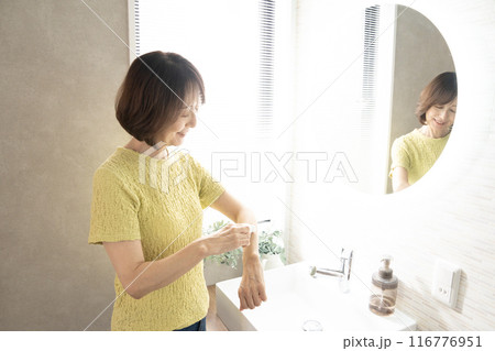 洗面所で腕の脱毛をする女性の手元 116776951