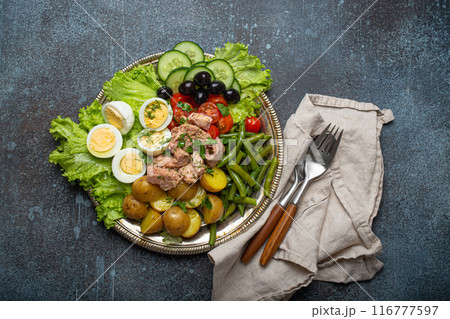 Nicoise salad with tuna, olives, green beans, tomatoes and quail eggs on a bed of lettuce 116777597