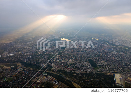 Aerial view from high altitude of distant city covered with puffy cumulus clouds forming before rainstorm in evening. Airplane point of view of cloudy landscape Aerial view from high altitude of distant city covered with puffy cumulus clouds forming before rainstorm in evening. Airplane point of view of cloudy landscape 116777706