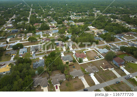 Aerial landscape view of suburban private houses between green palm trees in Florida rural area Aerial landscape view of suburban private houses between green palm trees in Florida rural area 116777720