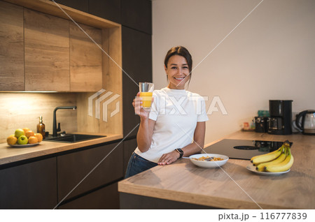 Young woman in casual clothes spending time at home and having breakfast 116777839